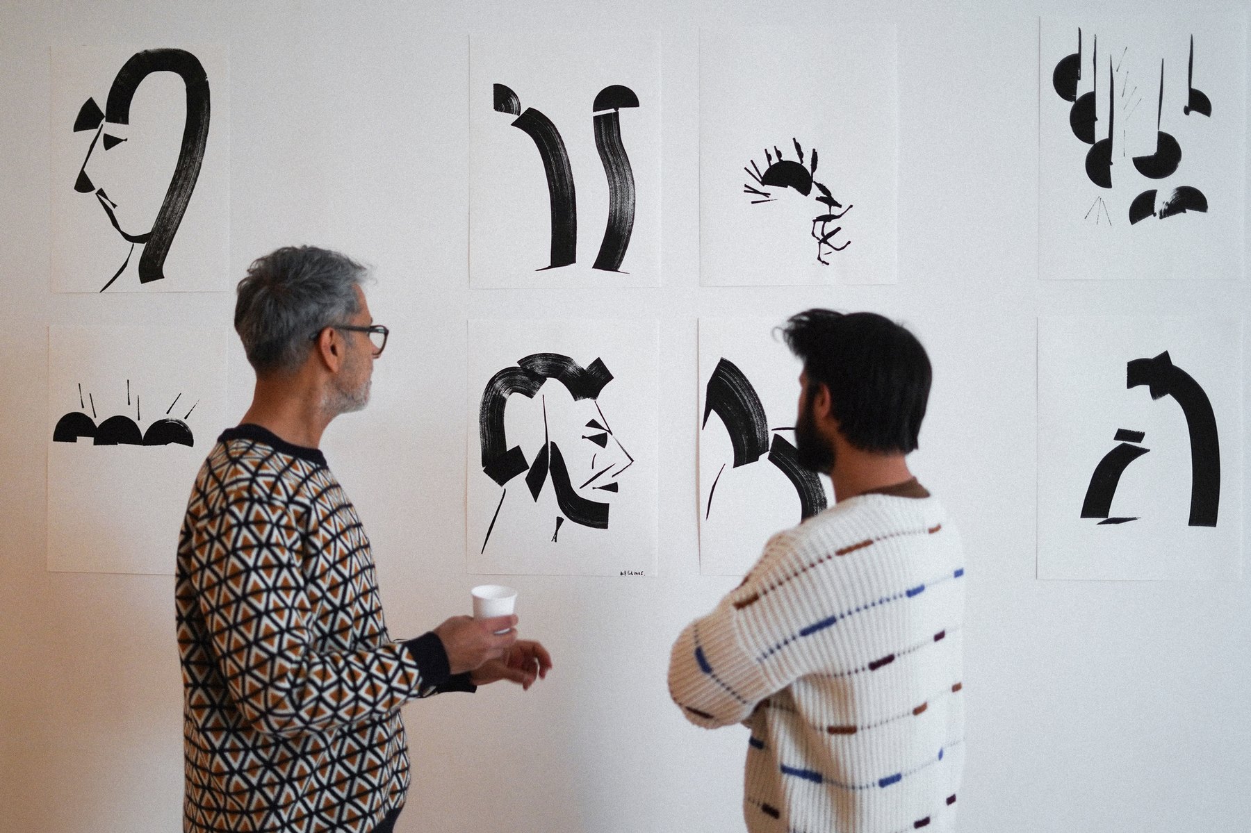 Mohammed Ismail at his gallery wall with a visitor